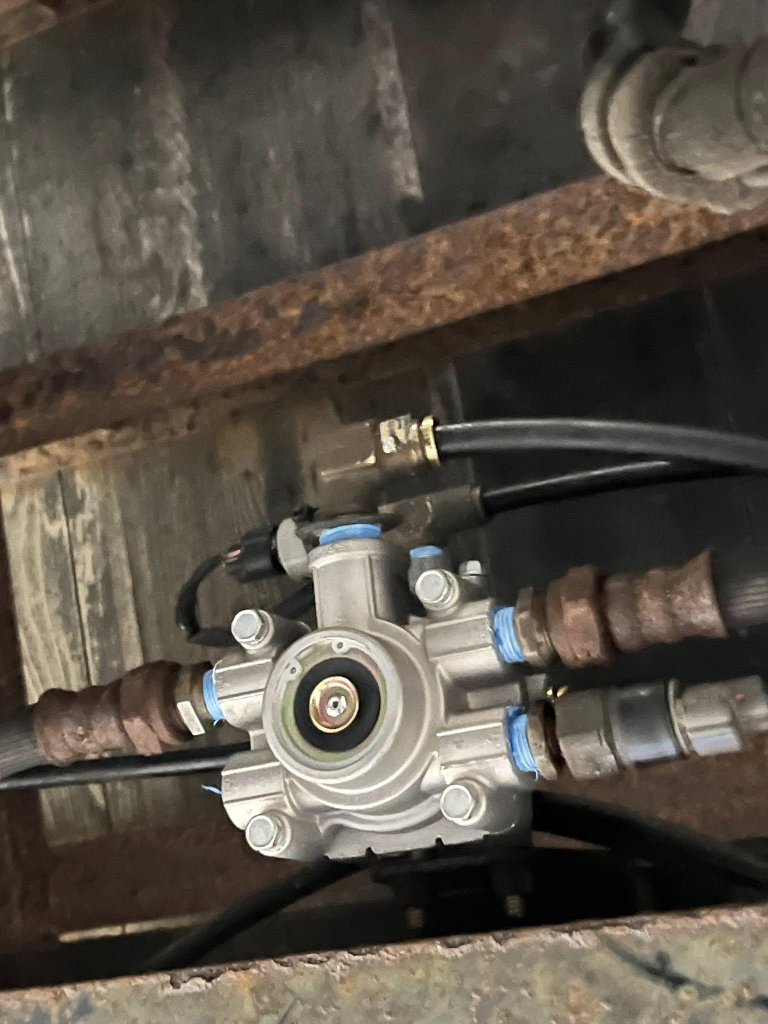 Air brake SR-7 valve mounted under truck — replacement in progress