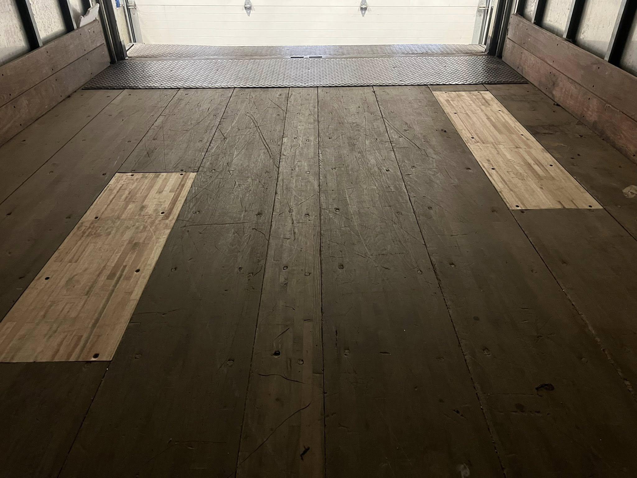 Box truck cargo floor with wood patches over rotted areas and new threshold plate