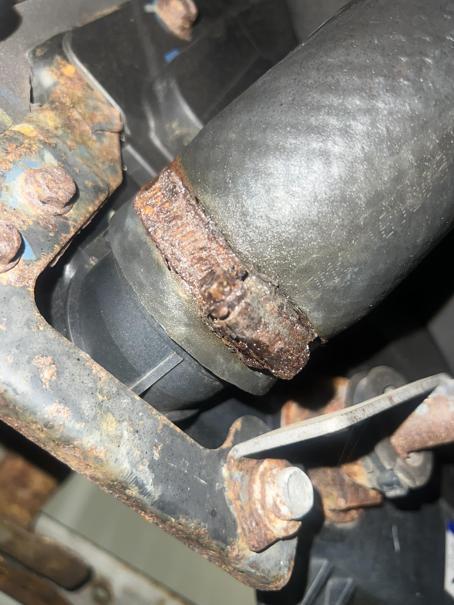Close-up of corroded coolant hose connection on a diesel engine