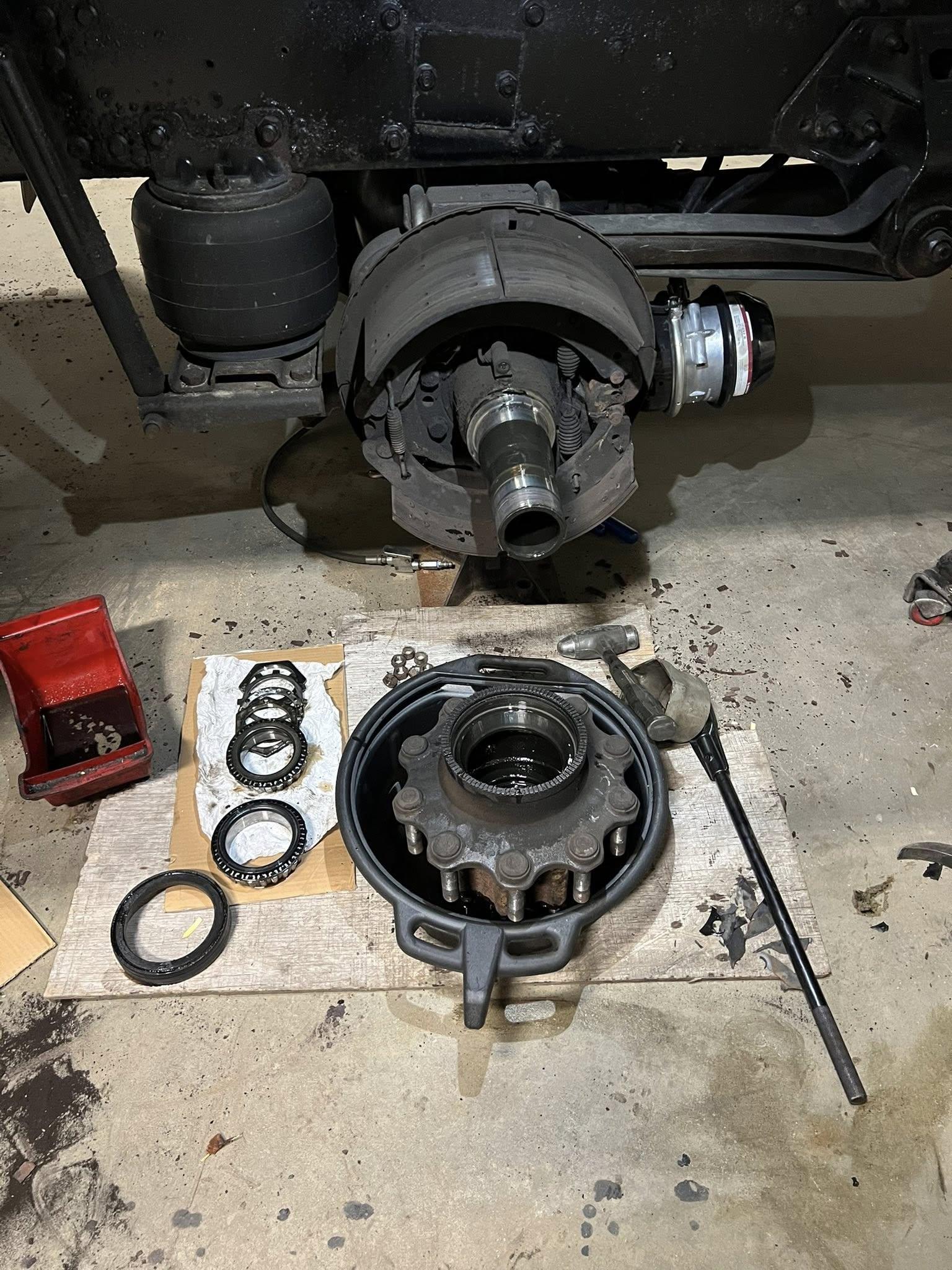 Truck axle hub disassembled with new wheel seal kit on the shop floor